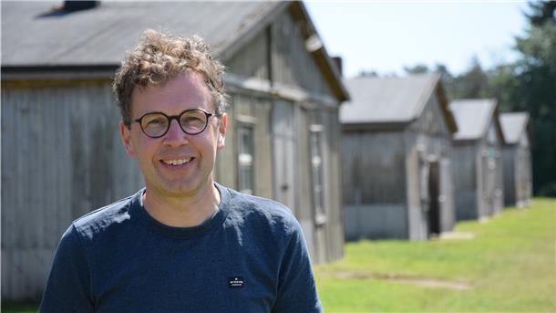 Friedenspädagoge Michael Freitag-Parey vor den noch erhaltenen Unterkunftsbaracken des ehemaligen Kriegsgefangenenlagers Stalag X B Sandbostel.