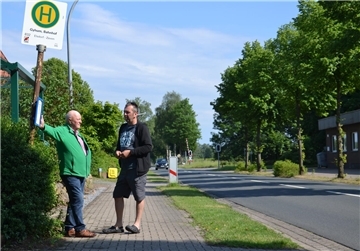 Friedhelm Dreyer und Sven Reichenbach (rechts) stehen an der Bushaltestelle am Bahnhof Gyhum.