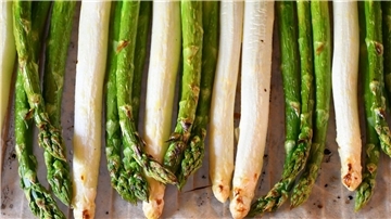 Grüner und weißer Spargel liegt nebeneinander. 