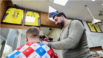 Friseur Taner Dogan schneidet in seinem Salon in einer Netto-Filiale einem Kunden  die Haare.