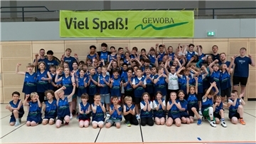 Junge Basketballer posieren für die Kamera.