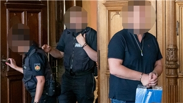Ein Mann betritt in Handschellen den Gerichtssaal. 