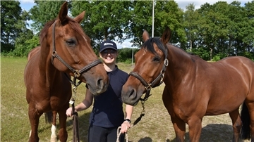 Eine Person hält zwei Pferde fest. Carlotta Kopitzki mit Doc'sDelight und Carisma.