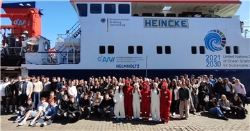 Gruppenfoto von rund 200 Schülerinnen und Schülern vor dem Forschungsschiff "Heincke" des Alfred-Wegener-Instituts in Bremerhaven bei sonnigem Wetter.