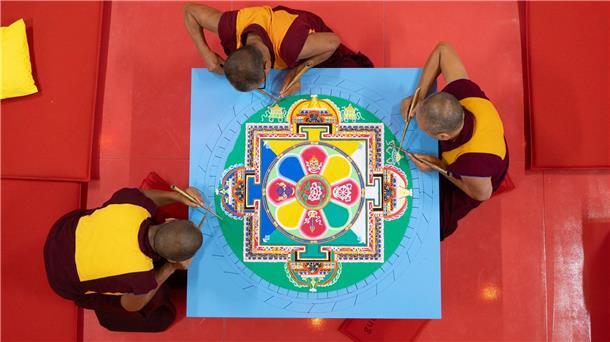 Bild aus buntem Sand Für ihr Mandala benötigen die Mönche aus Indien mehrere Tage.
