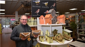 Für jeden Vogel im Garten gibt es die passende Nisthilfe. Gartenspezialist Michael Meyer hält in seinem Fachgeschäft fertige Nisthöhlen für Mehr- und Rauchschwalben in den Händen.