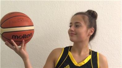 Ein Mädchen hält einen Basketball.