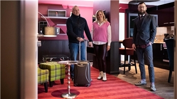 Drei Personen in einem Hotelzimmer