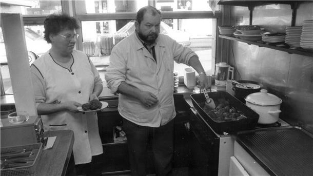 Schwarz-weiß-Foto von einem Mann und einer Frau in einem Imbiss.