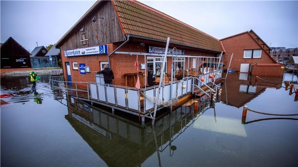 Großes Aufräumen nach Sturmflut mit Millionen-Schäden Gebäude im Fischereihafen in Wismar stehen nach der Sturmflut an der Ostseeküste im Wasser.