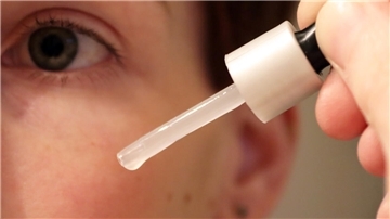 Gesicht und Pipette mit Flüssigkeit