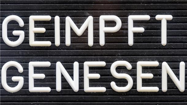 "Geimpft! Genesen!" steht auf einem Schild.
