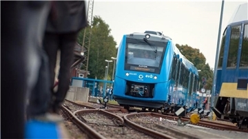 Ein Wasserstoffzug fährt über ein Bahngleis.