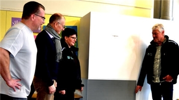 Gemeindetechniker Frank Tietjen und Annika Korb erklären Bürgermeister Detlef Wellbrock und Schulleiter Björn Bauch die Funktionsweise der modernen Luftreiniger.