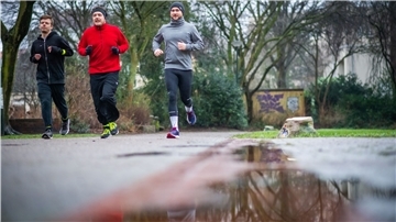 Drei Männer joggen.