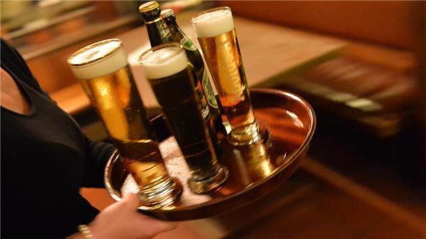 In einem Gasthaus wird auf einem Tablett Bier serviert. Thema: Mindestlohn.