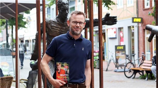 Ein Mann hält ein Buch.