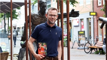 Ein Mann hält ein Buch.