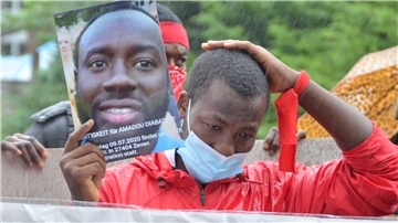 „Gerechtigkeit für Amadou Diabate“ steht auf einem Plakat, das ein Demonstrant in die Höhe hält. Es zeigt das Konterfei des in Zeven getöteten Ivorers.