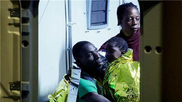 Gerettete Migranten gehen auf der italienischen Insel Lampedusa von einem Boot an Land.