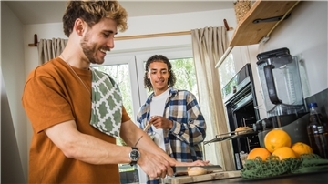 Zwei junge Männer kochen.