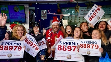 Gewinner der Weihnachtslotteriepreise feiern vor einer Lottoannahmestelle in Málaga.