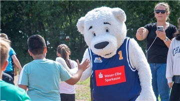 Dunky, Maskottchen der Eisbären Bremerhaven, begrüßt Kinder.