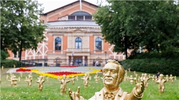 Goldfarbene Wagner-Figuren des Konzeptkünstler Ottmar Hörl stehen im Rahmen der Kunstinstallation „You’re welcome“ vor dem Festspielhaus.