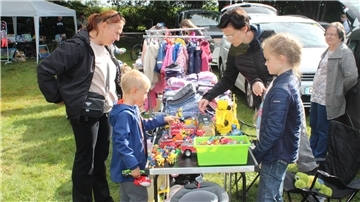 Kinder und Erwachsene am Flohmarktstand