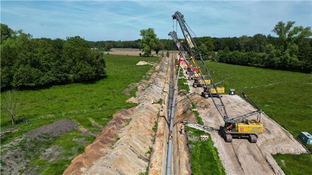 Erste Rohre für weitere LNG-Anbindungsleitung verlegt Große Baukräne hieven die Pipeline in den Rohrgraben.