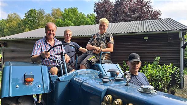 Großvater Günter Riethmüller (70/v.l.), Sohn Benny (41) und Enkel Tom Louis (15) fahren seit ihrer Kindheit Trecker. Kfz-Meister Michael Lartz (52/r.) hatte bei der Restaurierung des Lanz D 2806 Jahrgang 1955 den Hut auf.