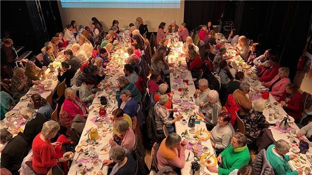 Viele Frauen sitzen an Tischen