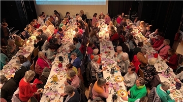 Viele Frauen sitzen an Tischen