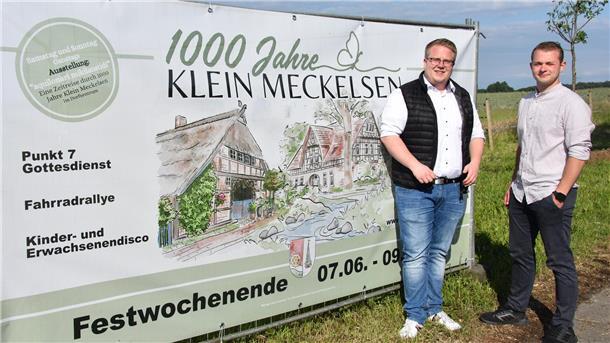 Das Foto zeigt Nico Burfeind und Janik Stemmann vor einem Festbanner. 