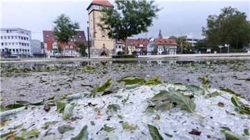 Hagelkörner und vom Sturm abgerissene Blätter liegen in Reutlingen auf dem Boden.