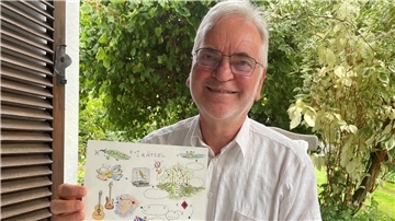Mann hält Bilderbogen in der Hand