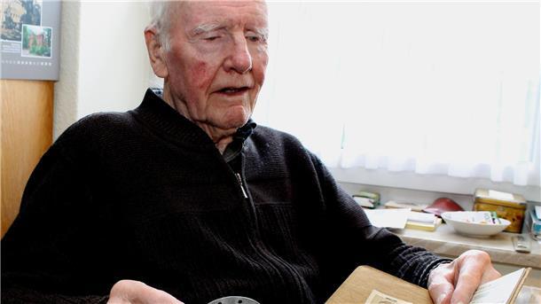 Hans Hermann Intemann mit Grenadier-Erkennungsmarke und dem Soldbuch der Wehrmacht, das zugleich als Personalausweis galt.