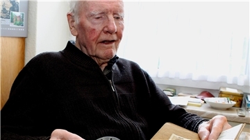Hans Hermann Intemann mit Grenadier-Erkennungsmarke und dem Soldbuch der Wehrmacht, das zugleich als Personalausweis galt.