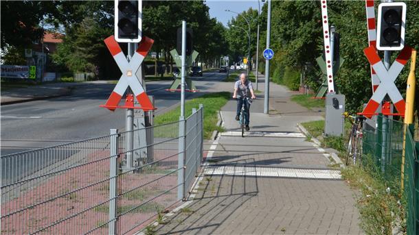 Hans Kist überquert mit seinem Fahrrad den Bahnübergang im Verlauf der Kivinanstraße.