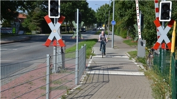 Hans Kist überquert mit seinem Fahrrad den Bahnübergang im Verlauf der Kivinanstraße.