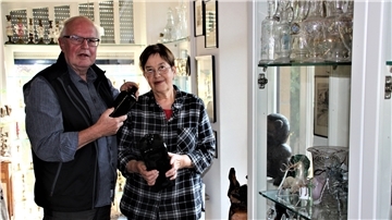 Harald und Magret Seyfarth sind leidenschaftliche Sammler: Auf diesem Foto hält der 71-jährige Rodenkircher eine niederländische Gin-Flasche in der Hand, die identisch ist mit der in Australien gefundenen bisher ältesten Flaschenpost der Welt. Seine Frau zeigt eine deutsche Vierkantflasche von Mitte des 18. Jahrhunderts.