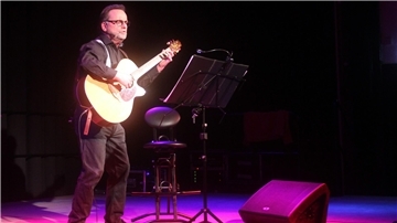 Ein Mann mit einer Gitarre. Hartmut Becker in der Jahnhalle