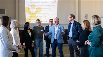 Hauke Blumhoff vom Amt für Arbeitsmarktpolitik (Mitte nach links) afz-Geschäftsführer Carsten Popp und Stadtrat Martin Günthner sprechen mit Teilnehmerinen und Projektbegleitenden der „Perspektive Arbeit für Frauen“ und „Perspektive Arbeit für Migrant:innen“ in der Theo.