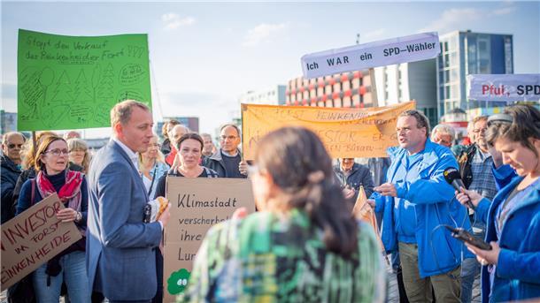 Hauke Hilz (FDP) stellt sich den Fragen, Forderungen und Sorgen der Demonstranten, die gegen den Verkauf des Reinkenheider Forsts auf die Straße gegangen sind.