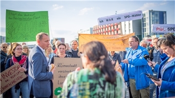 Hauke Hilz (FDP) stellt sich den Fragen, Forderungen und Sorgen der Demonstranten, die gegen den Verkauf des Reinkenheider Forsts auf die Straße gegangen sind.