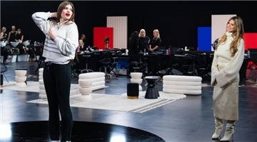 Eine Frau bewundert sich im Spiegel, eine andere schaut zu. Heidi Klum hat Xenia aus Loxstedt ein Umstyling verpasst bei GNTM.