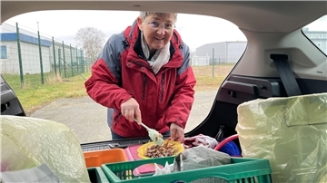 Frau befüllt Teller mit Katzenfutter
