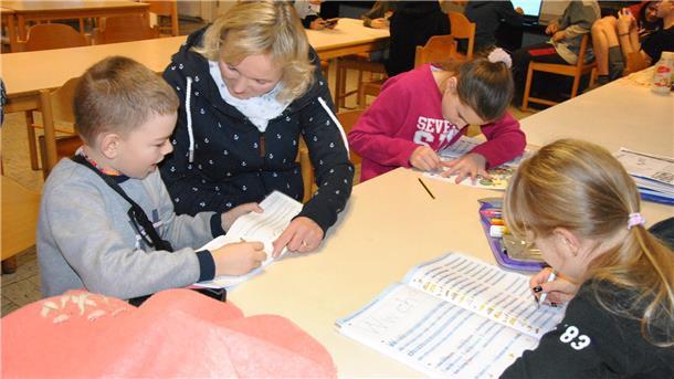 Heike Gathmann, Schulleiterin der Gosekamp-Grundschule Zeven, schaut den ukrainischen Flüchtlingskindern bei den Hausaufgaben in der ehemaligen Jugendherberge Bademühlen über die Schulter.