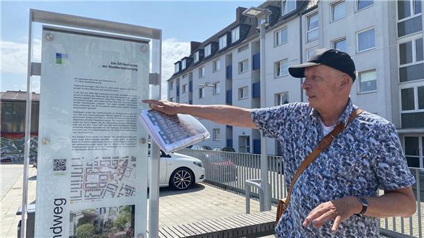 Heiko Janßen zeigt auf ein Schild im Quartier