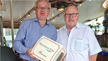 Heino Tietjen (rechts) überreicht im Namen der Schiffahrts-Compagnie die Spendenbox an Peter Klett, dem Vorsitzenden der Stiftung Maritimes Erbe (links).